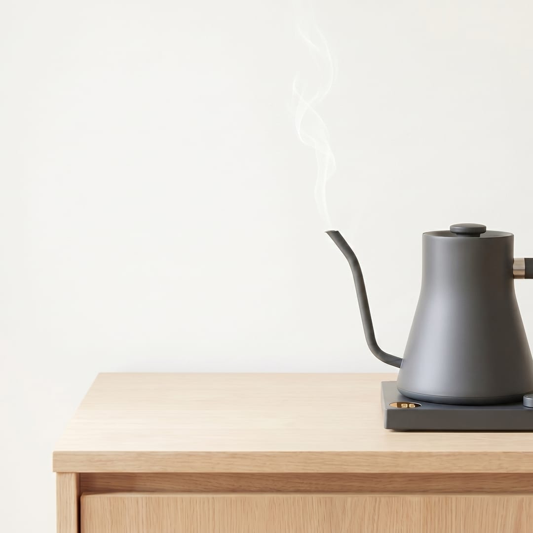 Aura kettle holding 96° — amber display lit, fine steam ribbon