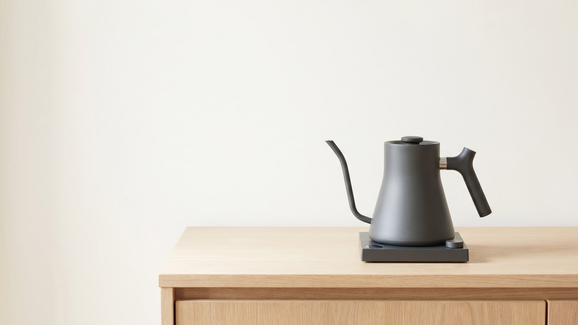 Aura kettle at rest on an oak counter — off, still